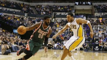 Feb 27, 2014; Indianapolis, IN, USA; Milwaukee Bucks guard O.J. Mayo (00) dribbles the ball in front of Indiana Pacers guard Evan Turner (12) at Bankers Life Fieldhouse. Mandatory Credit: Brian Spurlock-USA TODAY Sports