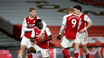 LONDON, ENGLAND - DECEMBER 26: Bukayo Saka of Arsenal celebrates with teammates Emile Smith Rowe, Alexandre Lacazette, and Hector Bellerin after scoring his team's third goal during the Premier League match between Arsenal and Chelsea at Emirates Stadium on December 26, 2020 in London, England. The match will be played without fans, behind closed doors as a Covid-19 precaution. (Photo by Andrew Boyers - Pool/Getty Images)