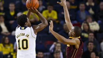 Jan 10, 2015; Ann Arbor, MI, USA; Michigan Wolverines guard Derrick Walton Jr. (10) shoots over Minnesota Golden Gophers guard Andre Hollins (1) in the second half at Crisler Center. Michigan won 62-57. Mandatory Credit: Rick Osentoski-USA TODAY Sports