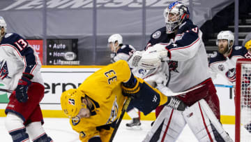 Joonas Korpisalo #70 of the Columbus Blue Jackets clears Viktor Arvidsson #33 of the Nashville Predators from the crease during the third period at Bridgestone Arena on January 14, 2021 in Nashville, Tennessee. Nashville defeats Columbus 3-1. (Photo by Brett Carlsen/Getty Images)