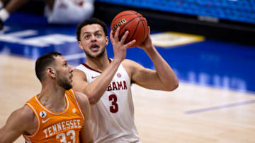 NASHVILLE, TN - MARCH 13: Alex Reese #3 of the Alabama Crimson Tide drives to the basket against Uros Plavsic #33 of the Tennessee Volunteers during the second half of their semifinal game in the SEC Men's Basketball Tournament at Bridgestone Arena on March 13, 2021 in Nashville, Tennessee. Alabama defeats Tennessee 73-68. (Photo by Brett Carlsen/Getty Images)