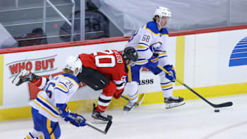 Feb 23, 2021; Newark, New Jersey, USA; Buffalo Sabres right wing Victor Olofsson (68) plays the puck against New Jersey Devils center Michael McLeod (20) during the second period at Prudential Center. Mandatory Credit: Vincent Carchietta-USA TODAY Sports