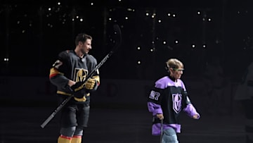 Shea Theodore #27 of the Vegas Golden Knights escorts his grandmother Kay Darlington off the ice after performing the ceremonial puck drop. (Photo by Ethan Miller/Getty Images)