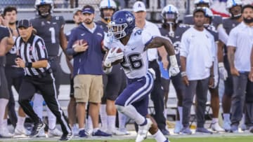 Nov 20, 2021; Orlando, Florida, USA; Connecticut Huskies running back Nathan Carter (26) runs the ball against the UCF Knights during the second quarter at Bounce House. Mandatory Credit: Mike Watters-USA TODAY Sports