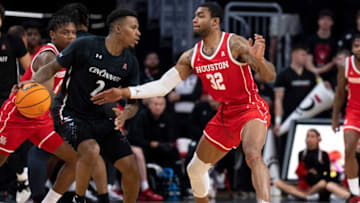 Cincinnati Bearcats guard Landers Nolley II drives on Houston Cougars forward Reggie Chaney at Fifth Third Arena. The Enquirer.