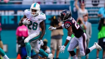 Oct 25, 2015; Miami Gardens, FL, USA; Miami Dolphins running back Lamar Miller (26) runs past Houston Texans defensive back Rahim Moore (26) during a game at Sun Life Stadium. Mandatory Credit: Steve Mitchell-USA TODAY Sports