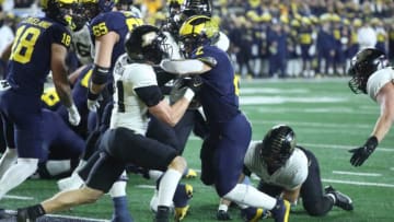 Michigan Wolverines running back Blake Corum (2) scores a touchdown over Purdue Boilermakers defensive back Sanoussi Kane (21) during the first half at Michigan Stadium, Saturday, Nov. 4, 2023.