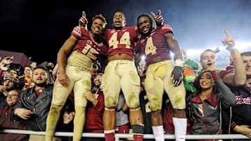 Nov 26, 2016; Tallahassee, FL, USA; Florida State Seminoles quarterback Deondre Francois (12), defensive end Demarcus Walker (44), and running back Dalvin Cook (4) celebrate after the Seminoles beat the Florida Gators at Doak Campbell Stadium. Mandatory Credit: Melina Vastola-USA TODAY Sports