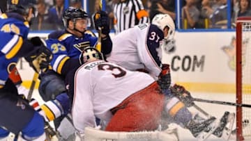 Sep 22, 2015; St. Louis, MO, USA; St. Louis Blues left wing Jordan Caron (33) crashes into Columbus Blue Jackets goalie Curtis McElhinney (30) during the second period at Scottrade Center. Mandatory Credit: Jasen Vinlove-USA TODAY Sports
