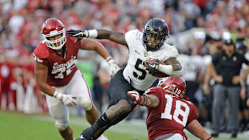 NORMAN, OK - SEPTEMBER 22: Running back Kell Walker #5 of the Army Black Knights dodges linebacker Curtis Bolton #18 of the Oklahoma Sooners at Gaylord Family Oklahoma Memorial Stadium on September 22, 2018 in Norman, Oklahoma. The Sooners defeated the Black Knights 28-21 in overtime. (Photo by Brett Deering/Getty Images)