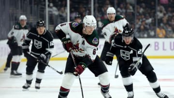 LOS ANGELES, CALIFORNIA - NOVEMBER 21: Jakob Chychrun #6 of the Arizona Coyotes skates with the puck as he is chased by Dustin Brown #23 of the Los Angeles Kings during the third period in a 2-1 Coyotes overtime win at Staples Center on November 21, 2021 in Los Angeles, California. (Photo by Harry How/Getty Images)