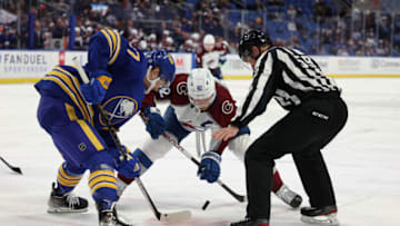 Feb 19, 2022; Buffalo, New York, USA; linesman Steve Barton (59) drops the puck for a face-off between Buffalo Sabres center Casey Mittelstadt (37) and Colorado Avalanche left wing Gabriel Landeskog (92) during the first period at KeyBank Center. Mandatory Credit: Timothy T. Ludwig-USA TODAY Sports
