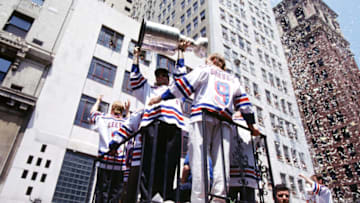 NEW YORK, NY - JUNE 17: Mark Messier #11 of the New York Rangers holds the Stanley Cup Trophy as his teammates Brian Leetch #2 and Adam Graves #9 ride along with him during the New York Rangers Stanley Cup Ticker-Tape Parade on June 17, 1994 after they defeated the Vancouver Canucks in New York, New York. (Photo by Bruce Bennett Studios/Getty Images)