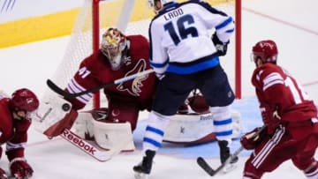 Oct 9, 2014; Glendale, AZ, USA; Arizona Coyotes goalie Mike Smith (41) makes a save on Winnipeg Jets left wing Andrew Ladd (16) during the first period at Gila River Arena. Mandatory Credit: Matt Kartozian-USA TODAY Sports