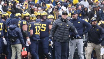 Michigan Wolverines head coach Jim Harbaugh, center, speaks with quarterbacks coach Matt Weiss, right, during action against the Ohio State Buckeyes on Saturday, Nov. 27, 2021 at Michigan Stadium.Michigan Ohio