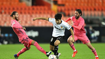 VALENCIA, SPAIN - NOVEMBER 08: Lee Kang-In of Valencia is challenged by Sergio Ramos and Isco of Real Madrid during the La Liga Santander match between Valencia CF and Real Madrid at Estadio Mestalla on November 08, 2020 in Valencia, Spain. Sporting stadiums around Spain remain under strict restrictions due to the Coronavirus Pandemic as Government social distancing laws prohibit fans inside venues resulting in games being played behind closed doors. (Photo by Angel Martinez/Getty Images)