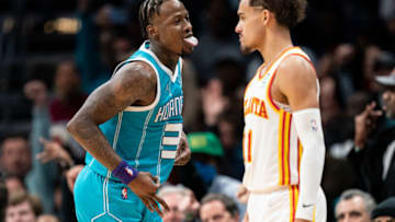CHARLOTTE, NORTH CAROLINA - MARCH 16: Terry Rozier #3 of the Charlotte Hornets reacts after making a 3-point shot while Trae Young #11 of the Atlanta Hawks looks on in the fourth quarter during their game at Spectrum Center on March 16, 2022 in Charlotte, North Carolina. NOTE TO USER: User expressly acknowledges and agrees that, by downloading and or using this photograph, User is consenting to the terms and conditions of the Getty Images License Agreement. (Photo by Jacob Kupferman/Getty Images)