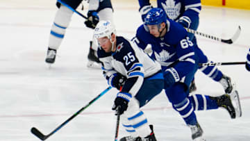 Apr 15, 2021; Toronto, Ontario, CAN; Winnipeg Jets forward Paul Stastny (25) tries to skate around Toronto Maple Leafs forward Ilya Mikheyev (65) during the first period at Scotiabank Arena. Mandatory Credit: John E. Sokolowski-USA TODAY Sports