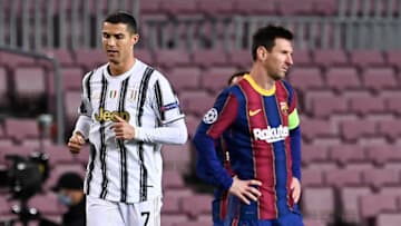 Juventus' Portuguese forward Cristiano Ronaldo (L) walks past Barcelona's Argentinian forward Lionel Messi. (Photo by JOSEP LAGO/AFP via Getty Images)