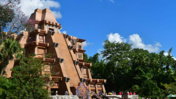 A Mayan temple stands out against blue sky while guest wait outside to go in. Photo by Brian Miller