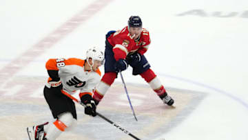 Oct 19, 2022; Sunrise, Florida, USA; Philadelphia Flyers center Morgan Frost (48) skates with the puck around Florida Panthers left wing Matthew Tkachuk (19) during the third period at FLA Live Arena. Mandatory Credit: Jasen Vinlove-USA TODAY Sports