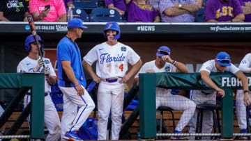 Jun 24, 2023; Omaha, NE, USA; Florida Gators second baseman Cade Kurland (4) talks with head coach Kevin O'Sullivan after scoring on a sacrifice fly by first baseman Jac Caglianone (not pictured) against the LSU Tigers during the third inning at Charles Schwab Field Omaha. Mandatory Credit: Dylan Widger-USA TODAY Sports