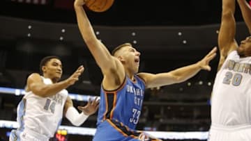 Oct 8, 2014; Denver, CO, USA; Oklahoma City Thunder forward Mitch McGary (33) prepares to dunk the ball as Denver Nuggets forward Jerrelle Benimon (20) and guard Gary Harris (14) defend during the second half at Pepsi Center. The Nuggets won 114-101. Mandatory Credit: Chris Humphreys-USA TODAY Sports