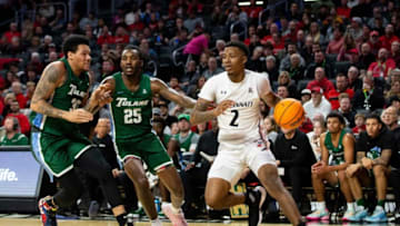 Cincinnati Bearcats guard Landers Nolley II drives toward basket against Tulane Green Wave. The Enquirer.