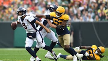 GREEN BAY, WISCONSIN - SEPTEMBER 22: Joe Flacco #5 of the Denver Broncos is pursued by Rashan Gary #52 of the Green Bay Packers during the first half at Lambeau Field on September 22, 2019 in Green Bay, Wisconsin. (Photo by Stacy Revere/Getty Images)
