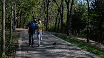 ISTANBUL, TURKEY - MAY 06: A man and woman wearing facemasks walk dogs in Macka Park during a three week nationwide coronavirus lockdown on May 06, 2021 in Istanbul, Turkey. The Turkish government imposed a three week lockdown from April 30 to May 17 in an attempt to slow the rising number of coronavirus infections across the country. In a bid to keep tourism and the economy going, tourists were exempt from the lockdown restrictions and some tourism and essential service businesses continue to be able to operate. Turkey has seen a rise in infections over the past months prompting the full lockdown. Since the start of the pandemic Turkey has recorded 4,955,594 cases of the virus and more than 41,883 deaths according to figures from John Hopkins University. (Photo by Burak Kara/Getty Images)