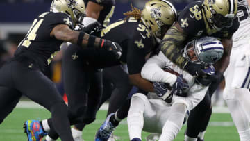 ARLINGTON, TEXAS - NOVEMBER 29: Vonn Bell #24, Cameron Jordan #94, and Demario Davis #56 of the New Orleans Saints combine to take down Ezekiel Elliott #21 of the Dallas Cowboys in the fourth quarter at AT&T Stadium on November 29, 2018 in Arlington, Texas. (Photo by Richard Rodriguez/Getty Images)