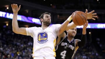Mar 22, 2014; Oakland, CA, USA; Golden State Warriors center Andrew Bogut (12) and San Antonio Spurs guard Danny Green (4) battle for a rebound in the fourth quarter at Oracle Arena. The Spurs defeated the Warriors 99-90. Mandatory Credit: Cary Edmondson-USA TODAY Sports