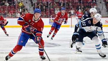 Sep 29, 2022; Montreal, Quebec, CAN; Montreal Canadiens forward Emil Heineman (51) plays the puck and Winnipeg Jets forward Mason Appleton (22) defends during the third period at the Bell Centre. Mandatory Credit: Eric Bolte-USA TODAY Sports