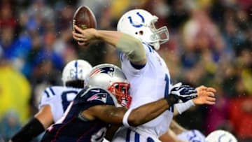 Jan 11, 2014; Foxborough, MA, USA; Indianapolis Colts quarterback Andrew Luck (12) throws a pass while being hit by New England Patriots outside linebacker Jamie Collins (91) during the third quarter of the 2013 AFC divisional playoff football game at Gillette Stadium. Mandatory Credit: Andrew Weber-USA TODAY Sports