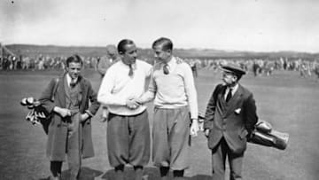 British golfer Henry Cotton (1907 - 1987), right, congratulating American player Walter Hagen (1892 - 1969) on breaking the record at the last hole at the British Open Golf Championship at Muirfield, watched by their caddies. Original Publication: People Disc - HH0235 (Photo by Topical Press Agency/Getty Images)