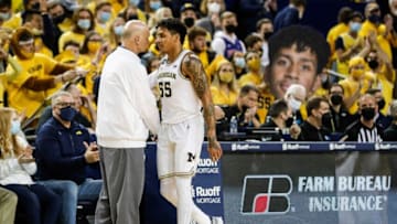 Michigan guard Eli Brooks (55) shakes hands with associate head coach Phil Martelli as he walks off the court during the second half against Iowa at the Crisler Center in Ann Arbor on Thursday, March 3, 2022.