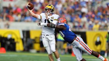 Jan 1, 2016; Orlando, FL, USA; Michigan Wolverines quarterback Jake Rudock (15) throws a pass as he pressured by Florida Gators linebacker Jarrad Davis (40) during the second quarter in the 2016 Citrus Bowl at Orlando Citrus Bowl Stadium. Mandatory Credit: Jim Dedmon-USA TODAY Sports