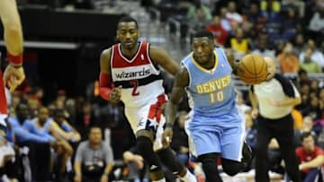 Dec 9, 2013; Washington, DC, USA; Denver Nuggets point guard Nate Robinson (10) leads a fast break as Washington Wizards point guard John Wall (2) chases during the second half at the Verizon Center. The Nuggets defeated the Wizards 75 - 74. Mandatory Credit: Brad Mills-USA TODAY Sports