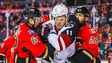 Nov 16, 2016; Calgary, Alberta, CAN; Arizona Coyotes center Martin Hanzal (11) and Calgary Flames defenseman Brett Kulak (61) and defenseman Deryk Engelland (29) fight during the second period at Scotiabank Saddledome. Mandatory Credit: Sergei Belski-USA TODAY Sports