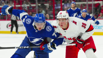 Sep 26, 2023; Raleigh, North Carolina, USA; Carolina Hurricanes right wing Noel Gunler (36) and Tampa Bay Lightning defensemen Emil Lillieberg (78) skate after the loose puck during the first period at PNC Arena. Mandatory Credit: James Guillory-USA TODAY Sports