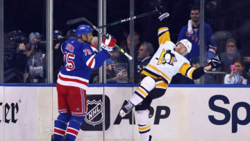 NEW YORK, NEW YORK - MAY 05: John Marino #6 of the Pittsburgh Penguins is checked by Ryan Reaves #75 of the New York Rangers during the first period in Game Two of the First Round of the 2022 Stanley Cup Playoffs at Madison Square Garden on May 05, 2022 in New York City. (Photo by Bruce Bennett/Getty Images)