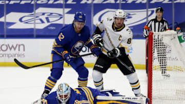 Mar 13, 2021; Buffalo, New York, USA; Buffalo Sabres defenseman Brandon Montour (62) and Pittsburgh Penguins center Sidney Crosby (87) watch as Buffalo Sabres goaltender Carter Hutton (40) covers the puck up during the third period at KeyBank Center. Mandatory Credit: Timothy T. Ludwig-USA TODAY Sports