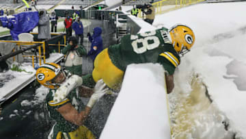 GREEN BAY, WISCONSIN - DECEMBER 27: AJ Dillon #28 and Cameron Batson #13 of the Tennessee Titans celebrate after Dillon scored a touchdown in the fourth quarter against the Tennessee Titans at Lambeau Field on December 27, 2020 in Green Bay, Wisconsin. (Photo by Dylan Buell/Getty Images)