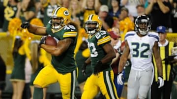 Aug 23, 2013; Green Bay, WI, USA; Green Bay Packers fullback Jonathan Amosa (48) celebrates with running back Johnathan Franklin (23) after scoring a touchdown in the 3rd quarter as Seattle Seahawks safety Jeron Johnson (32) watches at Lambeau Field. Mandatory Credit: Benny Sieu-USA TODAY Sports