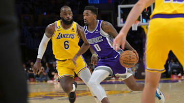 Oct 3, 2022; Los Angeles, California, USA; Sacramento Kings guard Malik Monk (0) drives to the basket past Los Angeles Lakers forward LeBron James (6) in the first half at Crypto.com Arena. Mandatory Credit: Jayne Kamin-Oncea-USA TODAY Sports