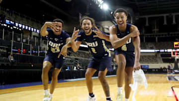 INDIANAPOLIS, INDIANA - MARCH 21: Sheldon Stevens #23, Kareem Thompson #2 and Jamie Bergens #4 of the Oral Roberts Golden Eagles celebrate after defeating the Florida Gators in the second round game of the 2021 NCAA Men's Basketball Tournament at Indiana Farmers Coliseum on March 21, 2021 in Indianapolis, Indiana. Oral Roberts defeated Florida 81-78. (Photo by Maddie Meyer/Getty Images)
