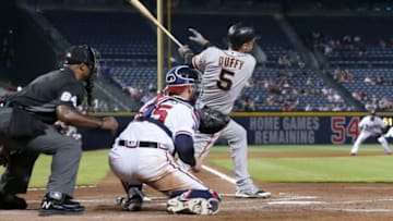 May 31, 2016; Atlanta, GA, USA; San Francisco Giants third baseman Matt Duffy (5) hits a sacrifice fly as Atlanta Braves catcher Tyler Flowers (25) is shown on the play in the 8th inning of their game at Turner Field. San Francisco Giants shortstop Brandon Crawford (not pictured) scored on the play. The Giants won 4-0. Mandatory Credit: Jason Getz-USA TODAY Sports