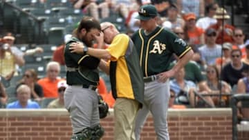 Jun 8, 2014; Baltimore, MD, USA; Oakland Athletics catcher Derek Norris (36) is attended to by assistant athletic trainer Walt Horn after being hit in the head by a bat swung by Baltimore Orioles third baseman Manny Machado (not shown) during the sixth inning at Oriole Park at Camden Yards. The Athletics won 11-1. Mandatory Credit: Joy R. Absalon-USA TODAY Sports