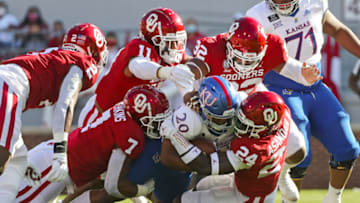 Nov 7, 2020; Norman, Oklahoma, USA; Kansas Jayhawks running back Daniel Hishaw Jr. (20) is tackled by Oklahoma Sooners linebacker Brian Asamoah (24) and defensive end Ronnie Perkins (7) and safety Delarrin Turner-Yell (32) and linebacker Nik Bonitto (11) during the first half at Gaylord Family-Oklahoma Memorial Stadium. Mandatory Credit: Kevin Jairaj-USA TODAY Sports