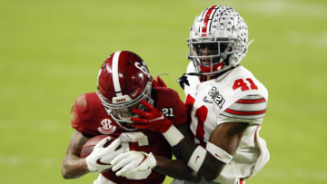 MIAMI GARDENS, FLORIDA - JANUARY 11: DeVonta Smith #6 of the Alabama Crimson Tide rushes ahead of Josh Proctor #41 of the Ohio State Buckeyes during the second quarter of the College Football Playoff National Championship game at Hard Rock Stadium on January 11, 2021 in Miami Gardens, Florida. (Photo by Sam Greenwood/Getty Images)